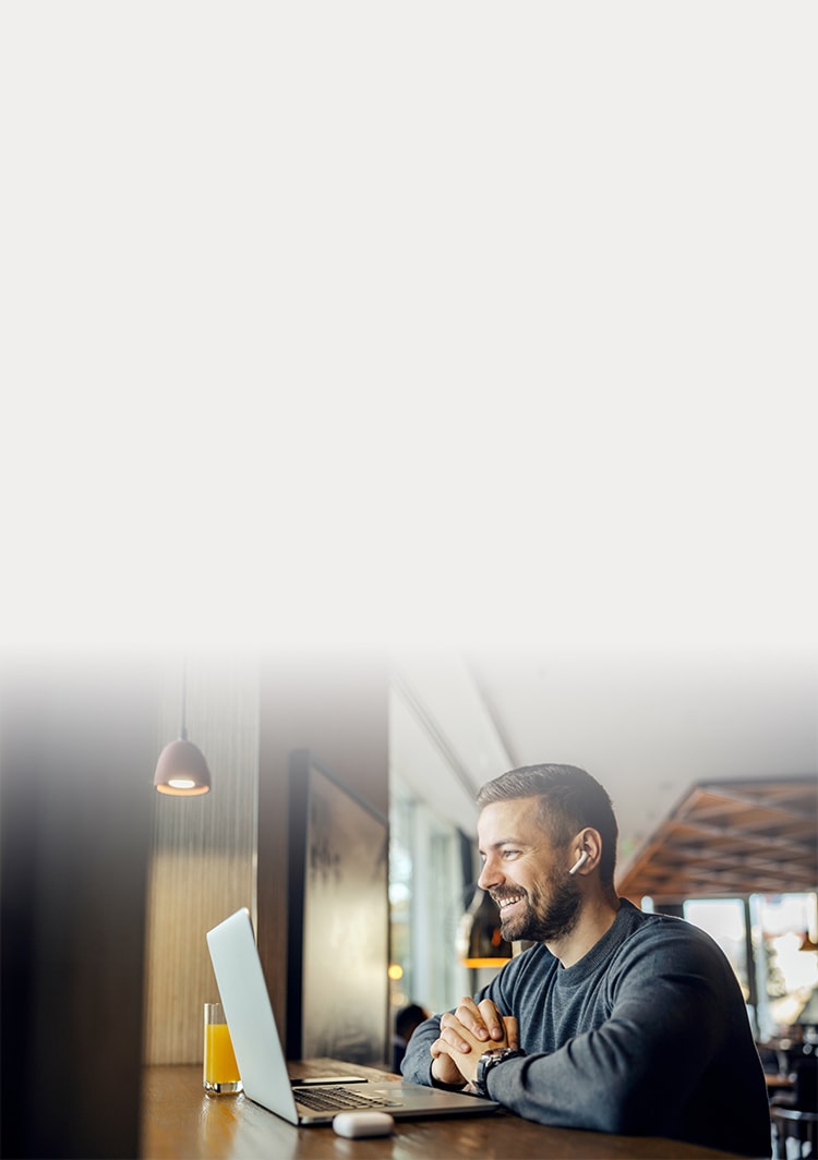 Hombre riendo mientras mira la computadora portátil