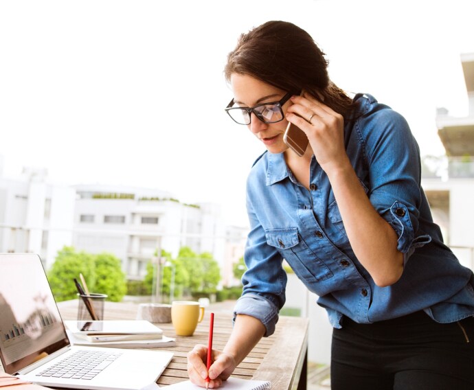 Mujer hablando por teléfono y trabajando.