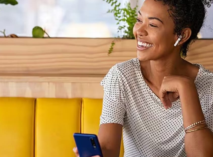 Mujer sentada riendo en una llamada